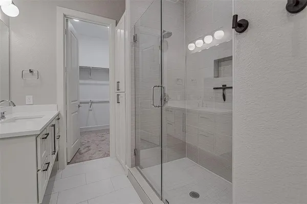 a bathroom with a shower sink and mirror