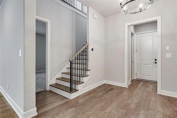 a view of a hallway with entryway wooden floor and front door