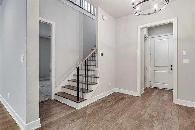 a view of a hallway with entryway wooden floor and front door