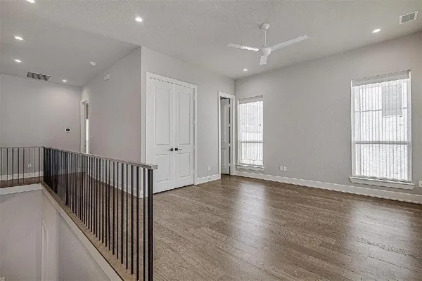 an empty room with wooden floor & windows