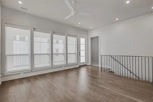 a view of an empty room with wooden floor