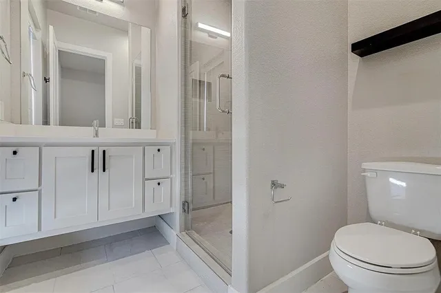 a bathroom with a granite countertop toilet and a shower