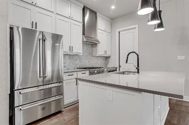 a kitchen with stainless steel appliances a refrigerator sink and cabinets