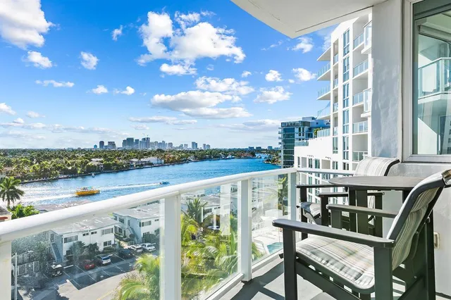 a view of city from a balcony with outdoor seating