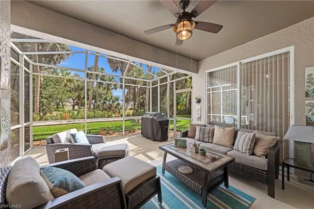 a living room with lots of furniture and a floor to ceiling window