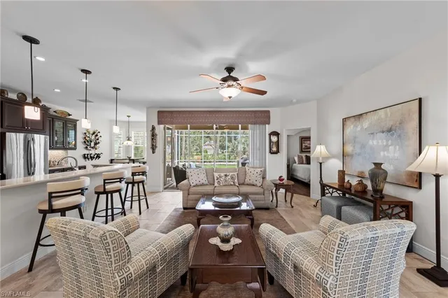 a living room with furniture kitchen view and a large window