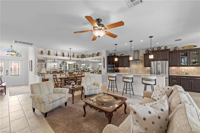 a living room with furniture kitchen view and a chandelier