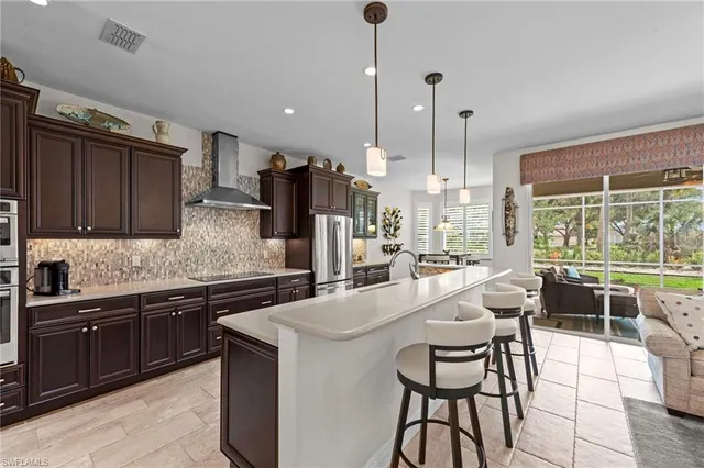 a kitchen with stainless steel appliances granite countertop wooden cabinets a stove a sink and a large window