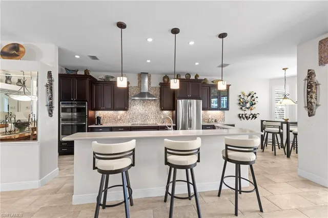 a kitchen with stainless steel appliances kitchen island granite countertop a table chairs and white cabinets