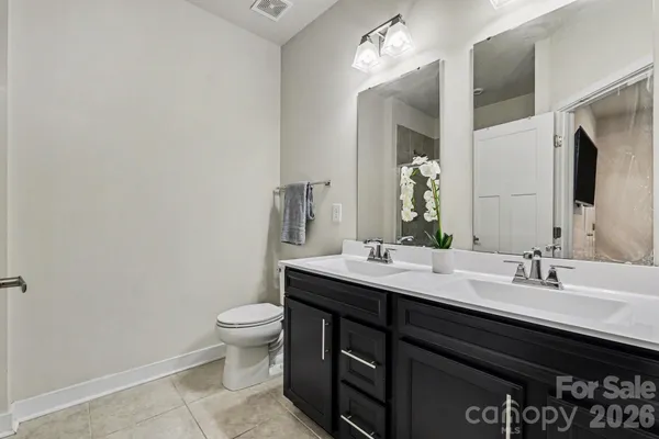 a bathroom with a double vanity sink toilet and mirror