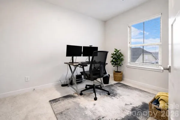 a view of a workspace with furniture and a window