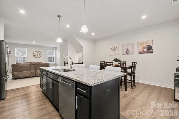 a large kitchen with kitchen island a sink table and chairs
