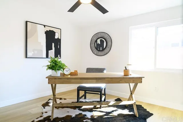 a table with a vase and flowers on it with table and chair