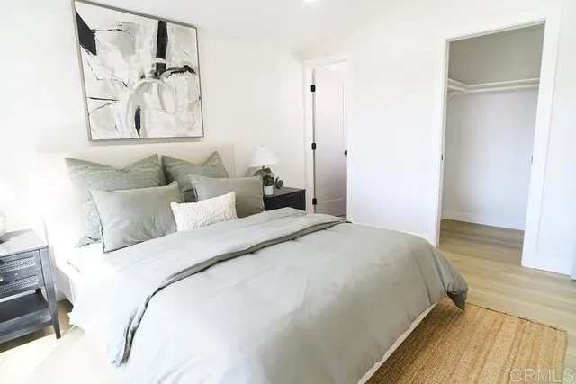 a bedroom with a bed and a painting on the wall