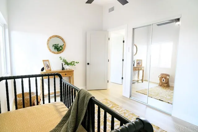 a view of a hallway with wooden floor and a bathroom