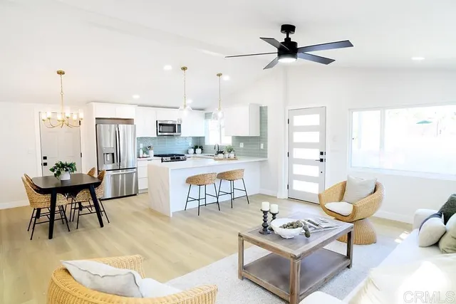 a living room with stainless steel appliances kitchen island granite countertop furniture and a large window