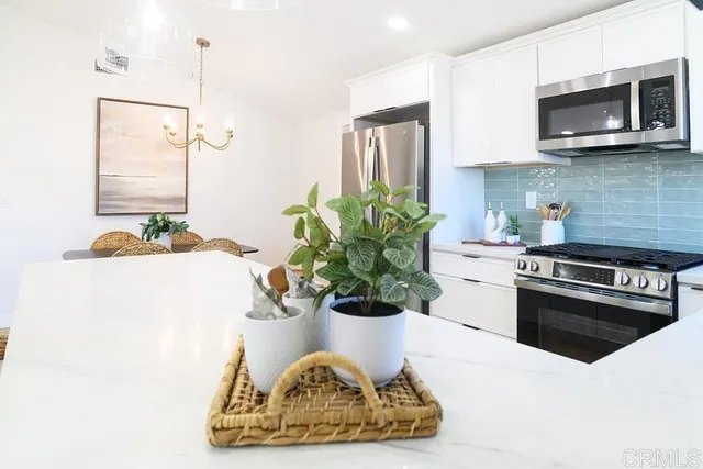 a white kitchen with a stove a microwave and cabinets