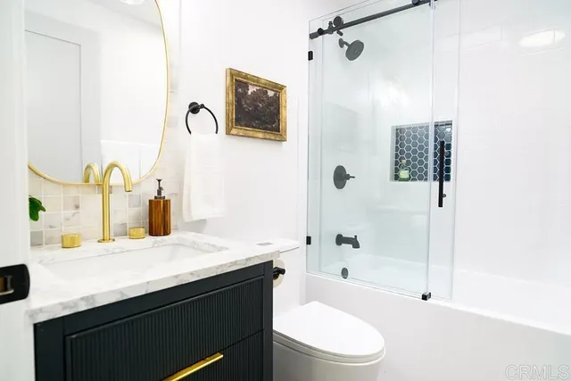 a bathroom with a sink a toilet and shower