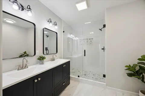 a bathroom with a bathtub shower sink double and mirror
