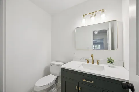 a bathroom with a sink vanity mirror and toilet
