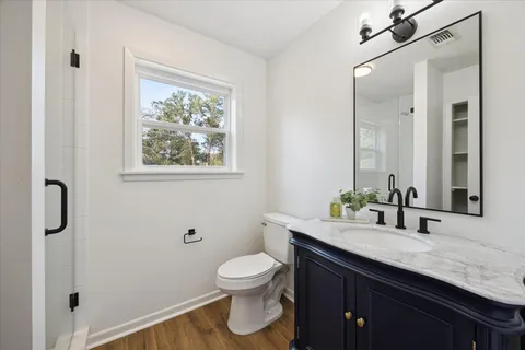 a bathroom with a granite countertop toilet sink and a mirror