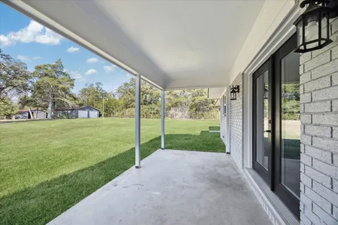 a view of green field with tree in front of it