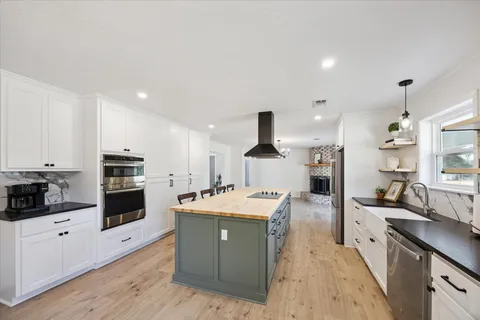 a large kitchen with stainless steel appliances and a stove