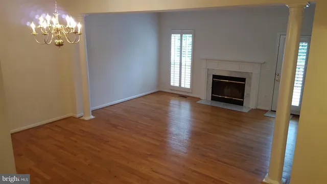 a view of empty room with wooden floor and fireplace