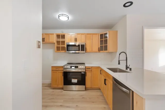a kitchen with stainless steel appliances granite countertop a stove a sink and a microwave