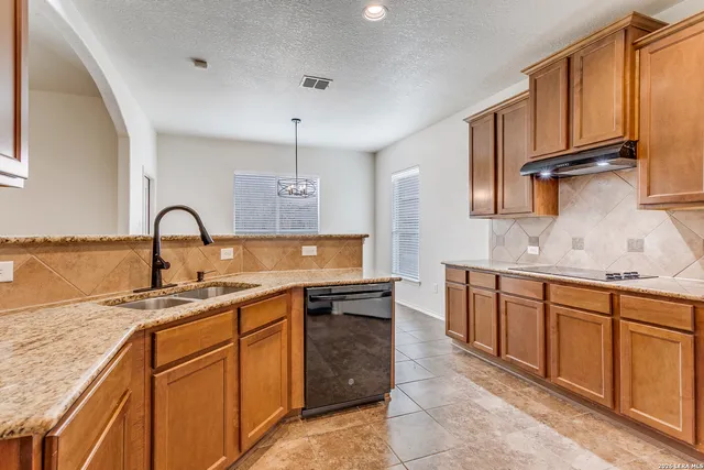 a kitchen with stainless steel appliances granite countertop a sink stove and cabinets