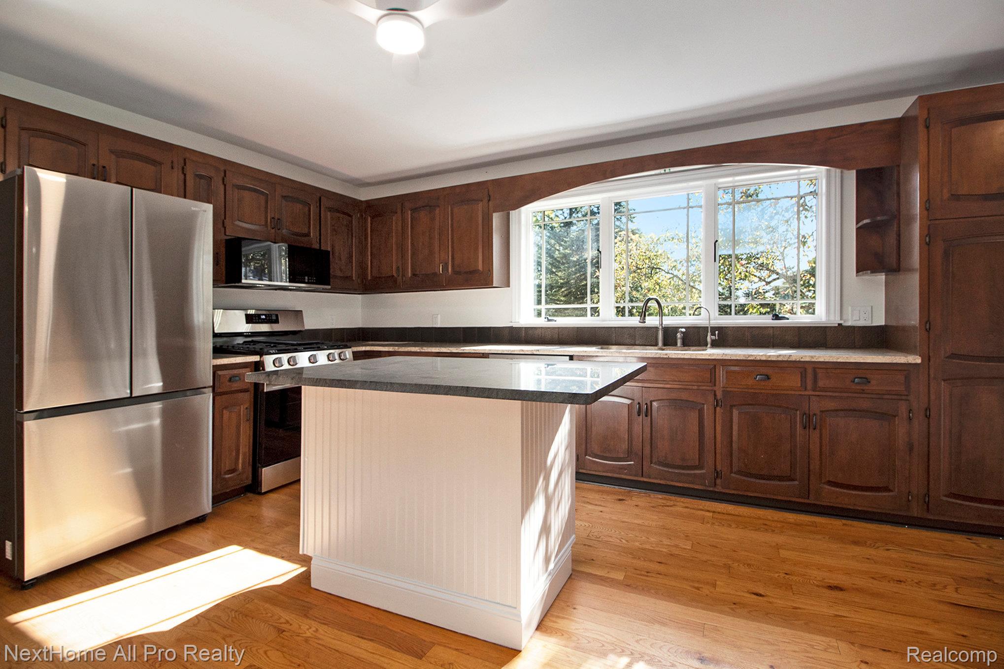 7195 Curtis Road Northville, MI 48168 - Photo 30 of 70 Kitchen featuring stainless steel appliances, quality cabinets with ample storage, and hardwood floors.