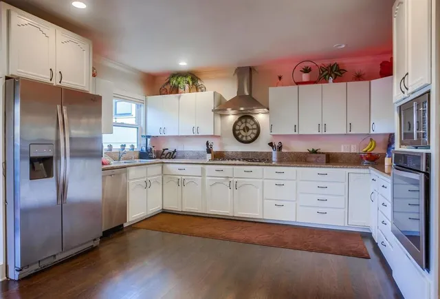 a kitchen with stainless steel appliances granite countertop a stove and cabinets