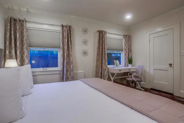 a bedroom with a large bed and a painting on the wall