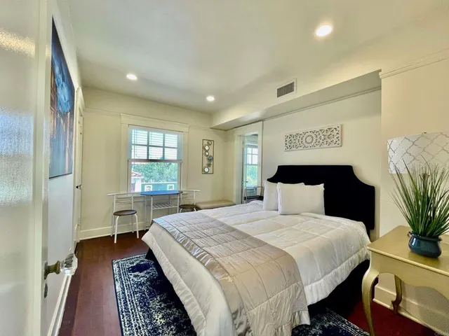 a room with wooden floor and a rug