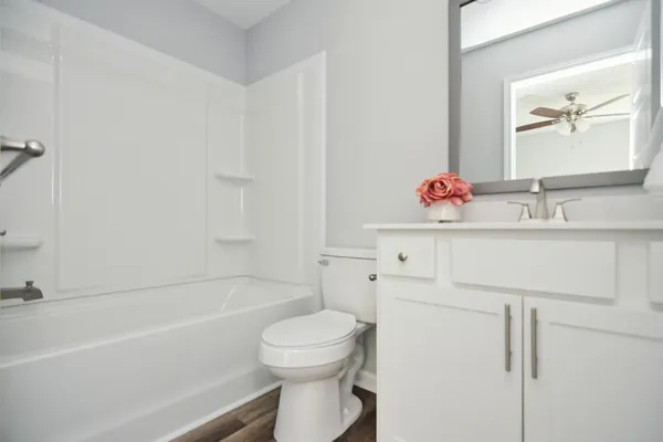 a bathroom with a sink toilet vanity and tub