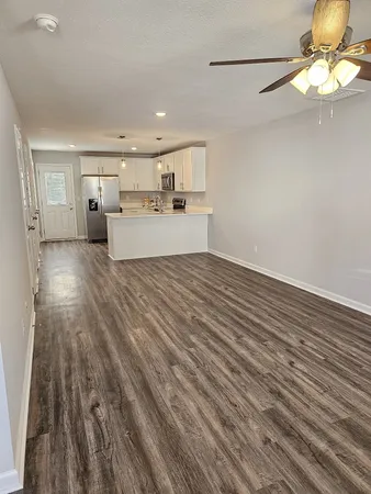 a view of a kitchen with wooden floor and a refrigerator