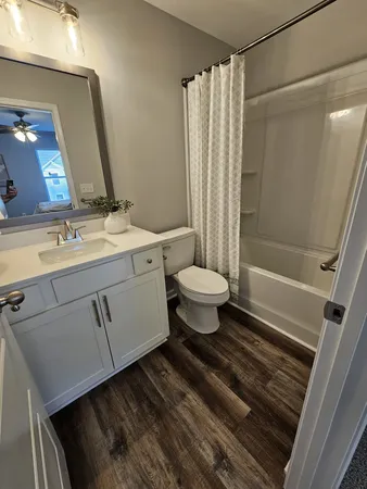 a bathroom with a sink toilet a mirror and shower