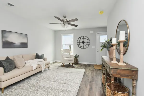 a living room with furniture a clock and a window