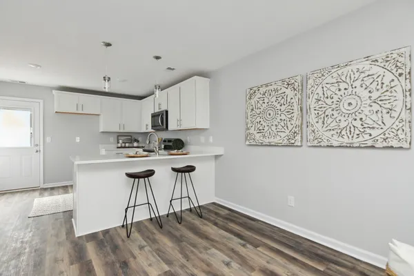 a kitchen with stainless steel appliances granite countertop a white cabinets and wooden floor