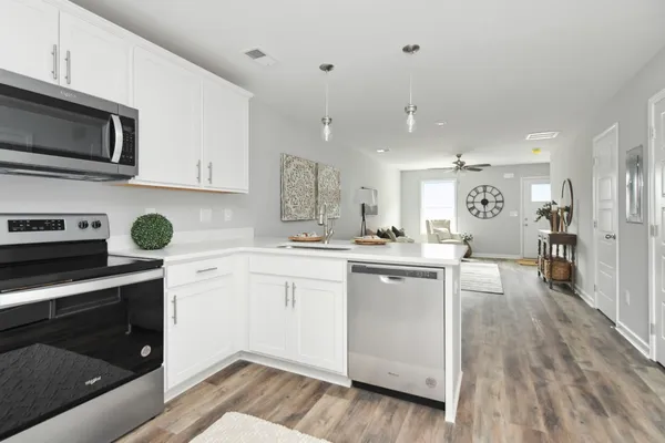 a kitchen with stainless steel appliances granite countertop a stove a sink and a microwave