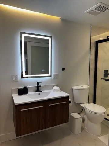 a bathroom with a toilet and a shower