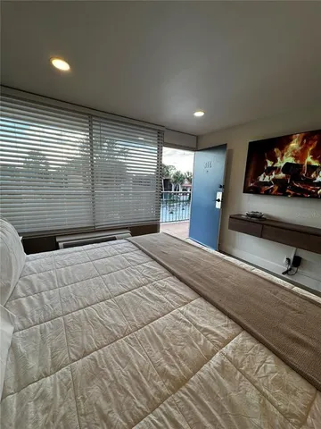 a spacious bedroom with a bed a couch and a television