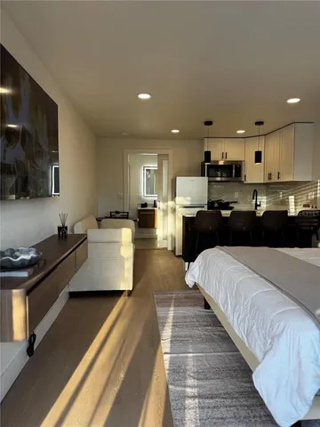 a bedroom with a bed and view of kitchen