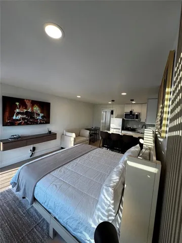 a living room with furniture kitchen view and a refrigerator