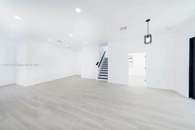 an empty room with wooden floor and white walls