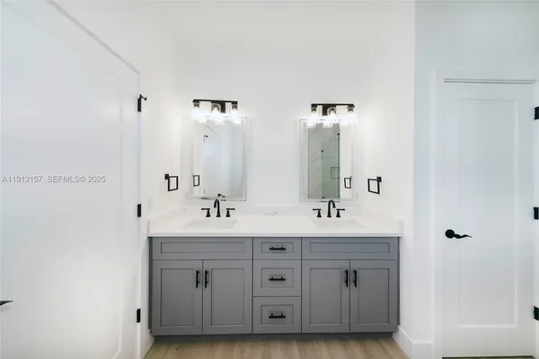 a bathroom with double vanity sinks and a mirror