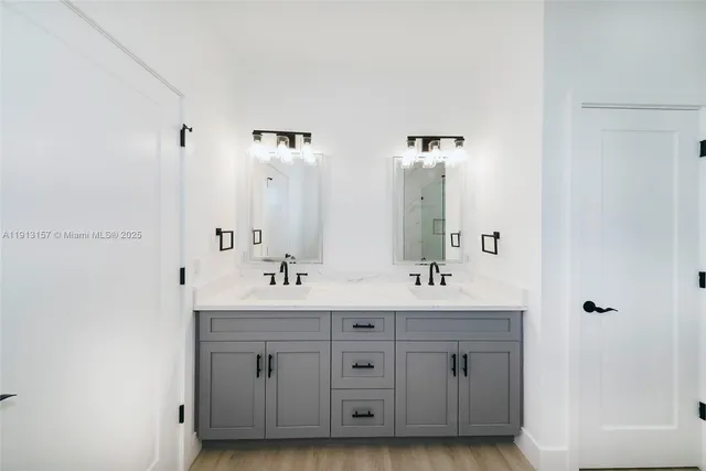 a bathroom with double vanity sinks and a mirror