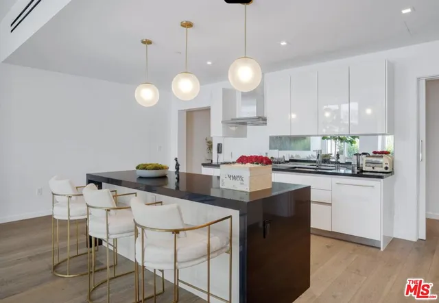 a kitchen with stainless steel appliances a stove a sink a cabinets and chairs