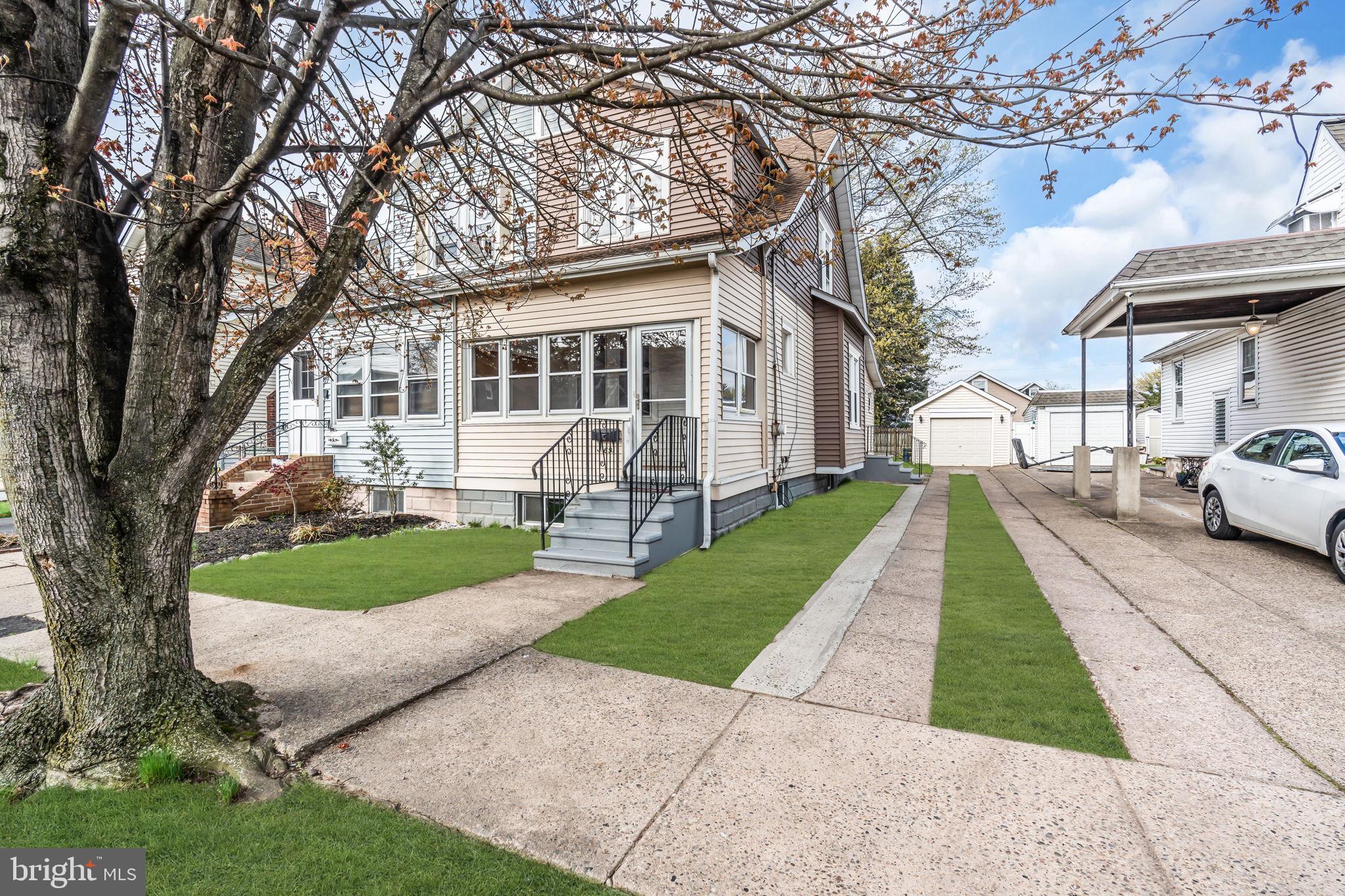 a front view of a house with a yard and trees