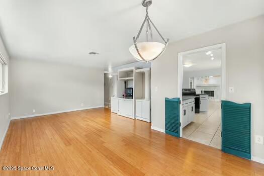 933 Waialae Circle Northeast Palm Bay, FL 32905 - Photo 18 of 32 a view of a livingroom with wooden floor and kitchen space